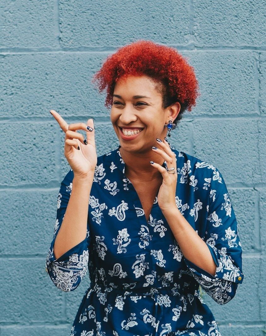 woman smiling while pointing on her right side